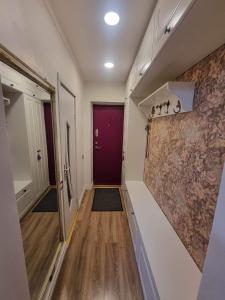 克莱佩达Senamiesčio butas的一间客房内带紫色门的走廊