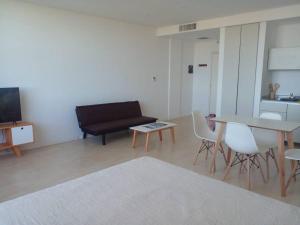 sala de estar con sofá, mesa y sillas en Departamento amoblado en Nordelta. en Benavídez