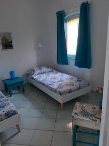 ein Schlafzimmer mit zwei Betten und einem Fenster in der Unterkunft Calarossa Sardinia Apartments in Isola Rossa