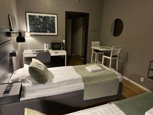 1 dormitorio con cama, escritorio y cocina en Hotel B&B Gränden en Skellefteå