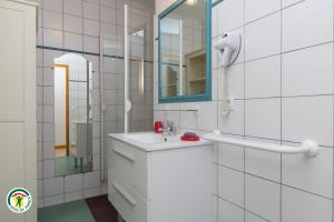 ein weißes Badezimmer mit Waschbecken und Spiegel in der Unterkunft au bonheur du cedre in Saint-Lattier + 19 Fotos