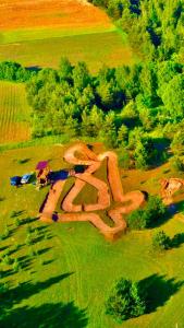 an aerial view of a field with a farm with cows at MilAdrija in Rokiškis