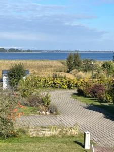 a garden with flowers and a view of the water at Bodden-Adler in Fuhlendorf