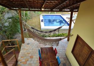 a porch with a hammock and a swimming pool at Pacha - Bangalôs em Pipa in Pipa