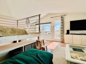 a bedroom with a bunk bed and a flat screen tv at Penthouse Studio Privée Couple ou Famille- La Maison Searle à Tourtour in Tourtour
