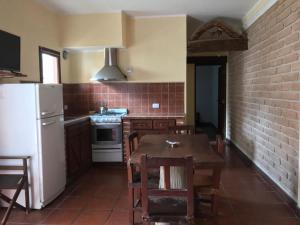 a kitchen with a table and a white refrigerator at Departamento Cafayate in Cafayate