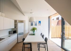 a kitchen with a white table and chairs at Les Camuches de la banque - Appartements privatifs de 35 à 110 m2 avec patios - Centre ville in Tournai