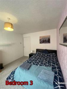 a bedroom with a bed with a blue comforter at Super deluxe extra large 3 bedroom apartment in Stanley