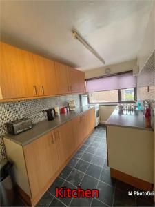 a kitchen with wooden cabinets and a black counter top at Super deluxe extra large 3 bedroom apartment in Stanley