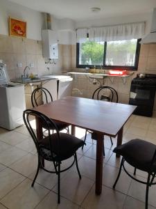 una mesa de madera y sillas en la cocina en Campo sereno en 