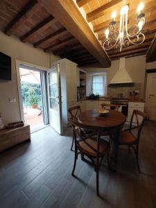 a kitchen and dining room with a table and chairs at Casina Laura in Capannori +7 photos