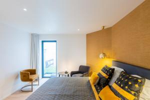 1 dormitorio con cama extragrande y sofá en Les Camuches en Tournai