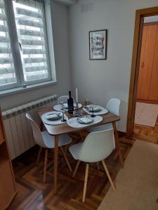 een eetkamer met een houten tafel en witte stoelen bij Apartman Đorđević in Kraljevo