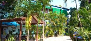 a building with palm trees in front of it at Shady transit hotel in Katunayaka
