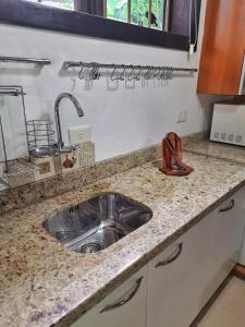una encimera de cocina con fregadero en una cocina en Casa dos beija Flores, 80 mts da praia do centro, en Bombinhas