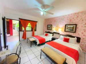 a hotel room with two beds and a ceiling fan at Hotel Camino Maya in Copán Ruinas