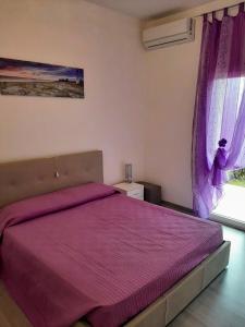een slaapkamer met een bed met een paarse sprei bij Residence Vigna del Mare in Gabicce Mare