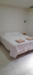 1 cama blanca grande con 2 toallas en Departamento Maipu centro en Maipú