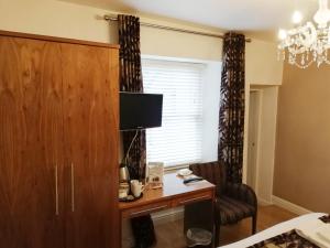 a bedroom with a desk and a chair and a window at Rooms at the Apple Pie in Ambleside