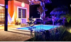 a house with a swimming pool at night at Paraíso Sítio da prainha in Pipa