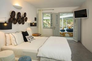a bedroom with a large white bed and a television at Blue Sand Boutique Hotel & Suites in Agali
