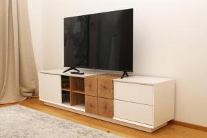 a flat screen tv on a white entertainment center at OrestaLiving - View of Vienna in Vienna