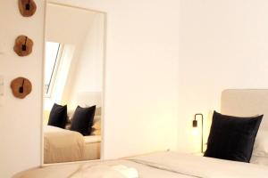 a bedroom with a mirror in front of a bed at OrestaLiving - View of Vienna in Vienna