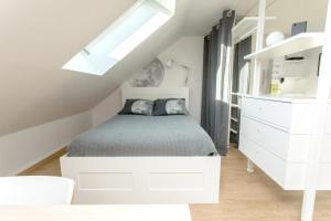 a white bedroom with a bed and a white dresser at Appartement Luna Hypercentre Gare à 300m in Pontchâteau