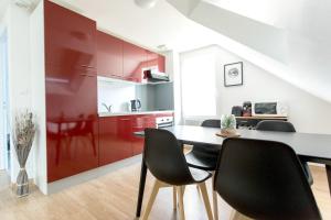 une cuisine avec des placards rouges, une table et des chaises dans l'établissement Appartement Luna Hypercentre Gare à 300m, à Pontchâteau