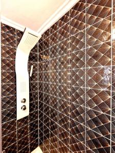 a brown tiled wall with a hair dryer on it at Chabós Jardín del Posío in Ourense