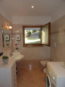 a bathroom with two sinks and a toilet and a window at Ciasa Gran Panorama Moena in Moena