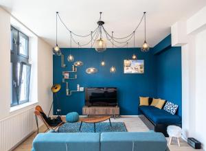 a living room with blue walls and a blue couch at Les Camuches in Tournai