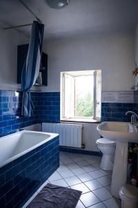 baño azul y blanco con bañera y lavamanos en maison bourgeoise, en Rouffignac