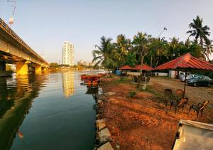 a river with a bridge and some tables and chairs at Shalom Palace in Cochin