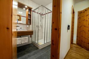 uma casa de banho com um chuveiro e um lavatório. em Hotel Raunig em Bad Kleinkirchheim