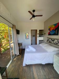 Recanto Ipê Amarelo في باراتي: غرفة نوم بسرير ومروحة سقف