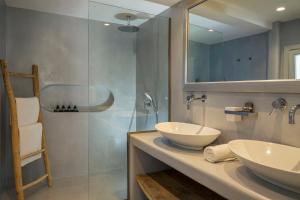 a bathroom with two sinks and a glass shower at Blue Sand Boutique Hotel & Suites in Agali +37 photos