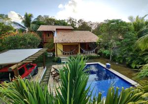 een huis met een zwembad naast een resort bij Pacha - Bangalôs em Pipa in Pipa