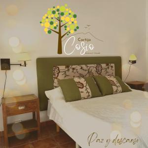 a bedroom with a bed with a sign on the wall at Cortijo EL COSIO in Benamaurel