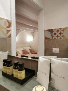 una habitación con una cama y un estante con algunos aceites en Vecchia Mottola Albergo Diffuso, en Mottola