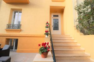 a building with stairs and flowers in front of a door at Maison familiale niçoise avec terrasse in Nice