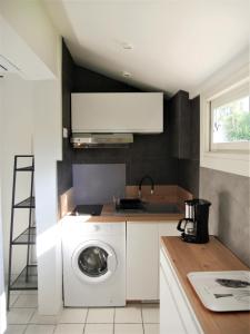 a kitchen with a washing machine and a sink at Charmant T2 bord de mer in Anglet