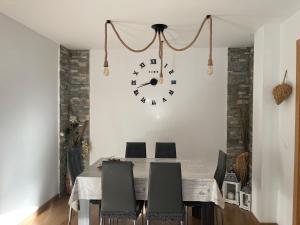 a dining room with a table and a clock on the wall at Piso Victoria in Guardiola de Berguedà