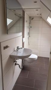 bagno con lavandino, servizi igienici e specchio di Ferienwohnung Sternenstube a Völkenroth