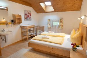 a bedroom with two beds and a sink and a bathroom at Hartlhof Urlaub am Baby- und Kinderbauernhof in Niederau
