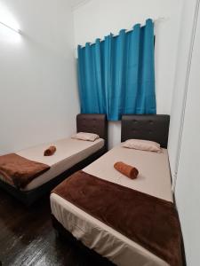 Amilite Heritage Villa في جورج تاون: سريرين في غرفة مع ستائر زرقاء