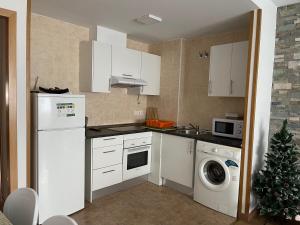 eine Küche mit weißen Geräten und einem Weihnachtsbaum darin in der Unterkunft Apartameto Verena Deluxe in Guardiola de Berga