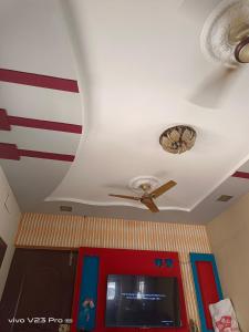 uma ventoinha de tecto e uma televisão num quarto em GT em Chennai