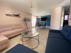 a living room with a couch and a table at Magnifique villa moderne Jacuzzi 4 chambres 3 salle de bain proche plage centre ville activité in Le Barcarès