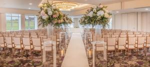 a row of chairs and tables in a room with flowers at Old Course Hotel St Andrews in St. Andrews